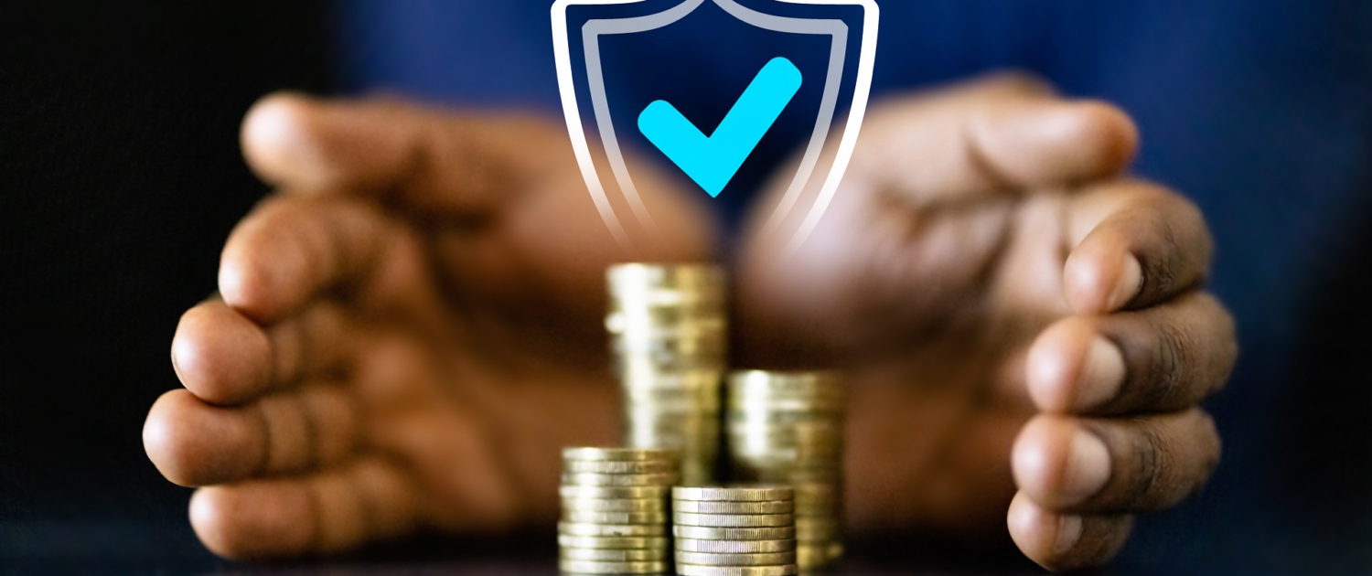 Zwei Hände umschließen einen Stapel Münzen. Darüber ist ein Schild mit einem blauen Hacken projiziert, dass die Sicherheit des Geldes symbolisiert.
