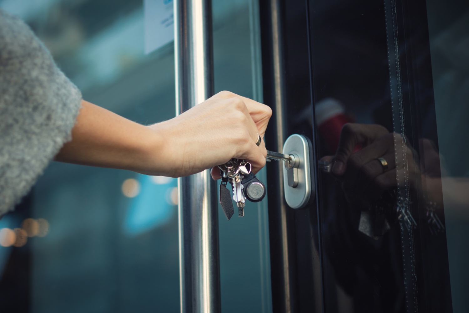 Hand schließt eine Haustür mit einem Schlüssel ab – Einbruchschutz für ein sicheres Zuhause